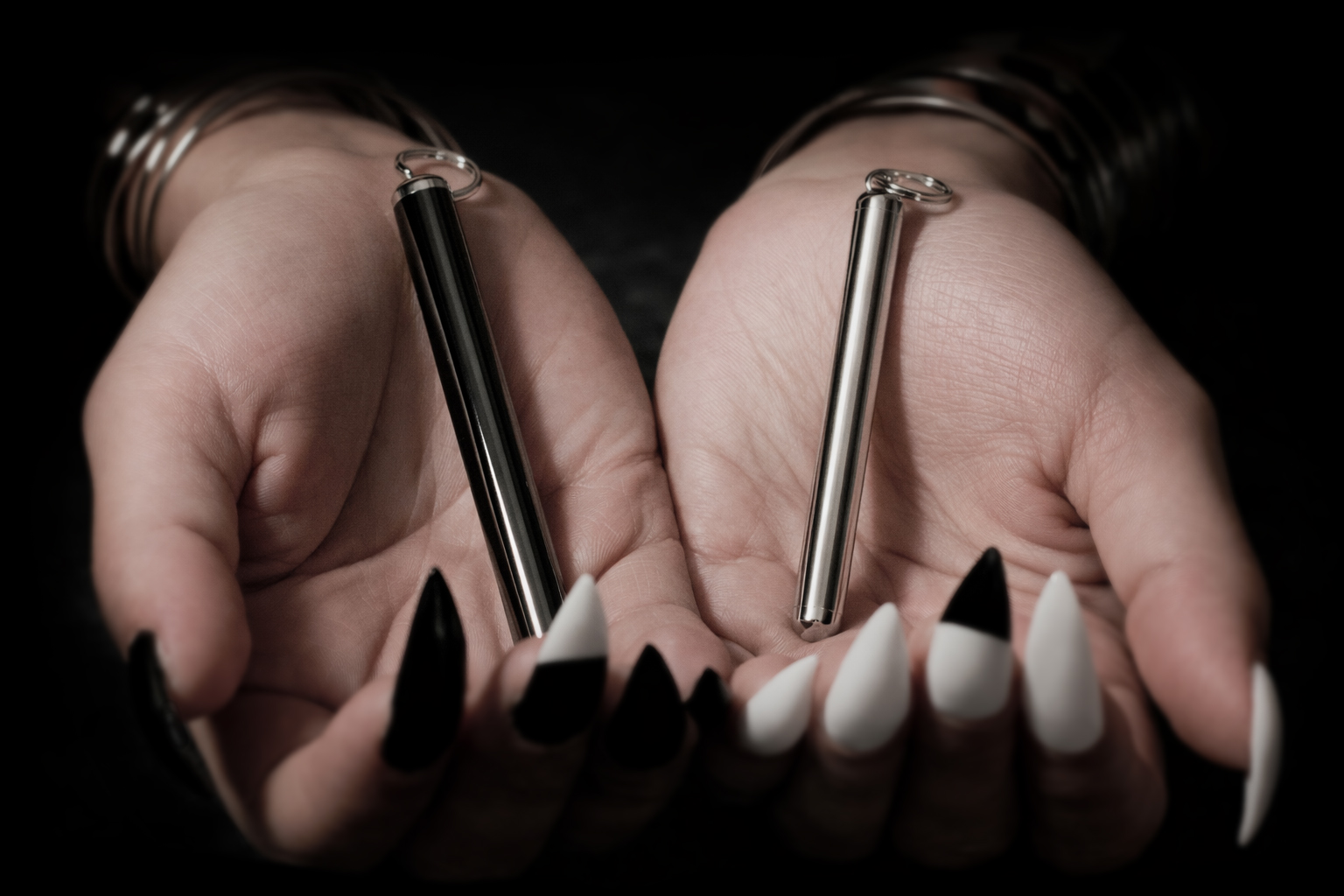 Woman holding black chrome and mirror chrome PURC metal vials
